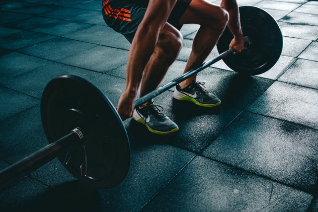 A man lifting a lot of weight at a gym.